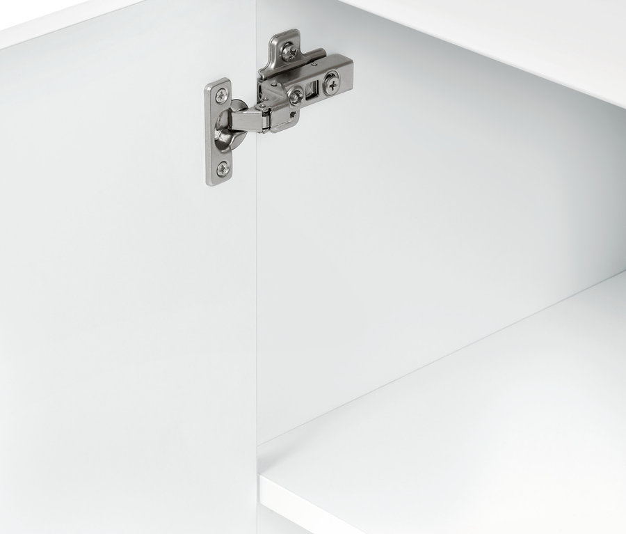 Détail d'un meuble de salle de bain blanc avec porte ouverte et charnières.
