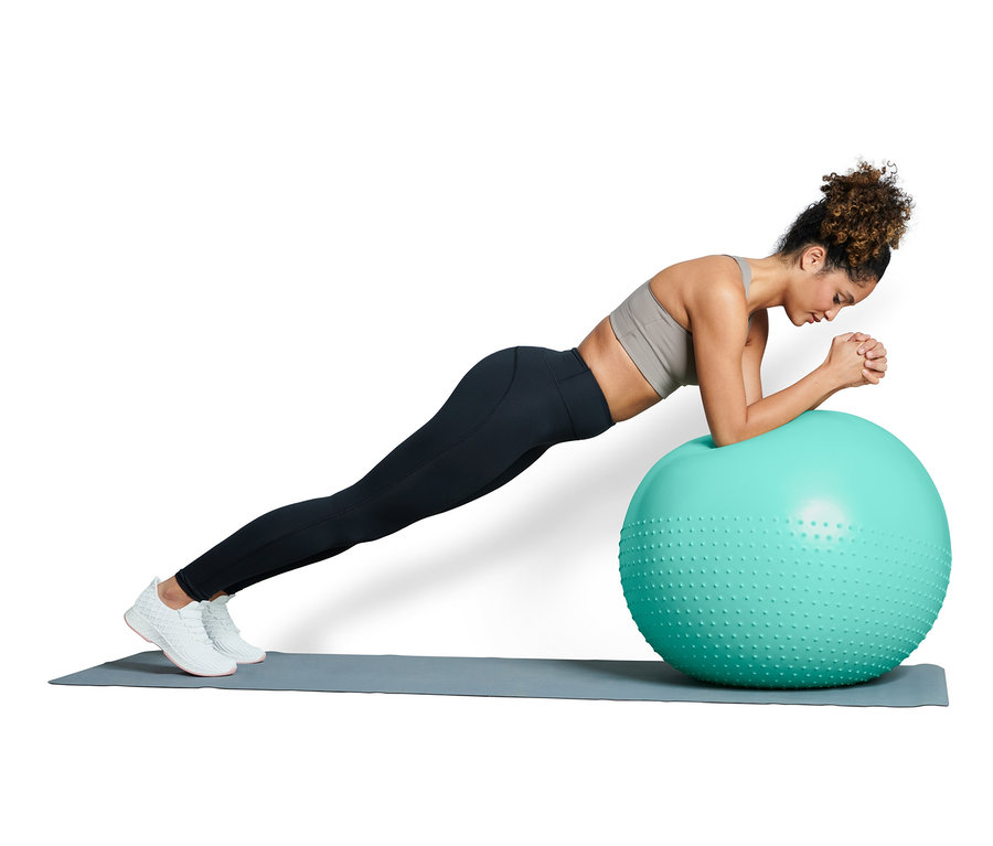 Femme faisant du planking sur un ballon de gymnastique.