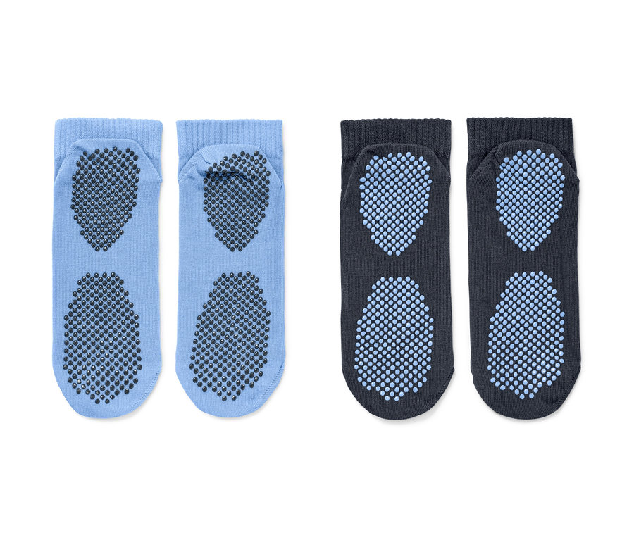 Deux paires de chaussettes de yoga. Une paire est bleu clair avec des picots gris foncé, l'autre paire est gris foncé avec des picots bleu clair.