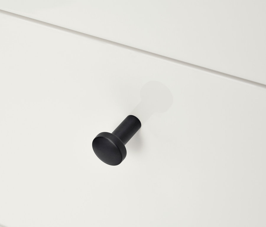Détail d'une commode blanche « Bekeson » avec une poignée noire.