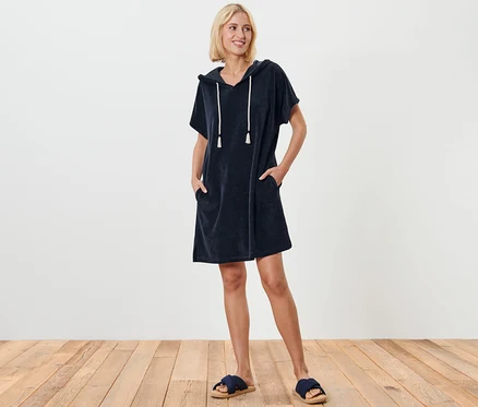 Femme debout posant en robe de plage en tissu éponge bleue.