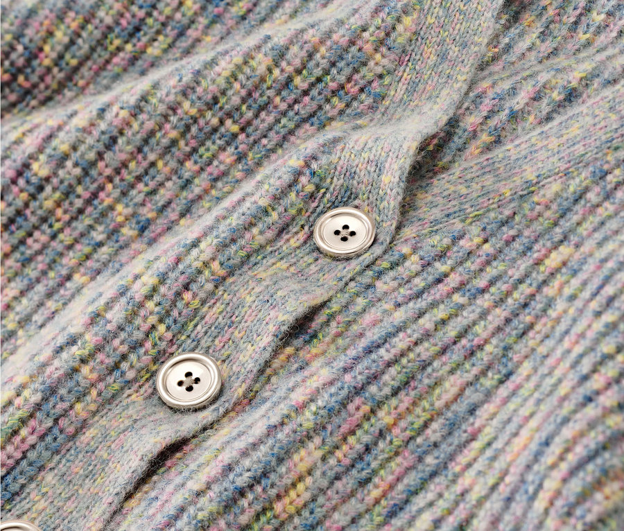 Gros plan sur une jaquette en maille pour enfant avec de la laine et des boutons.