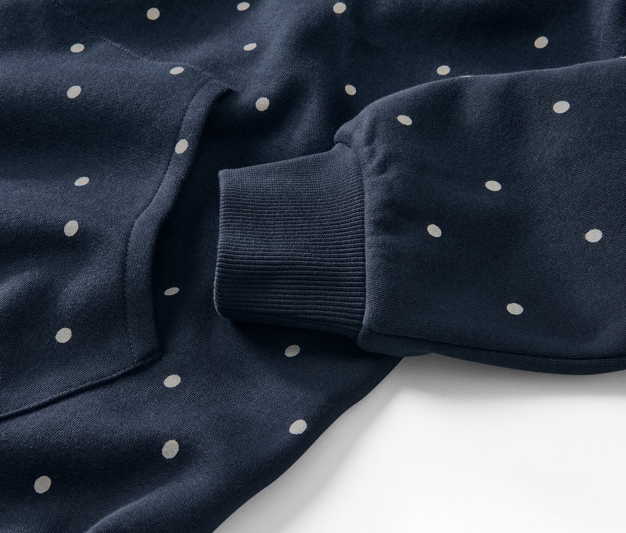 Gros plan sur une robe d’intérieur bleu marine à pois blancs.