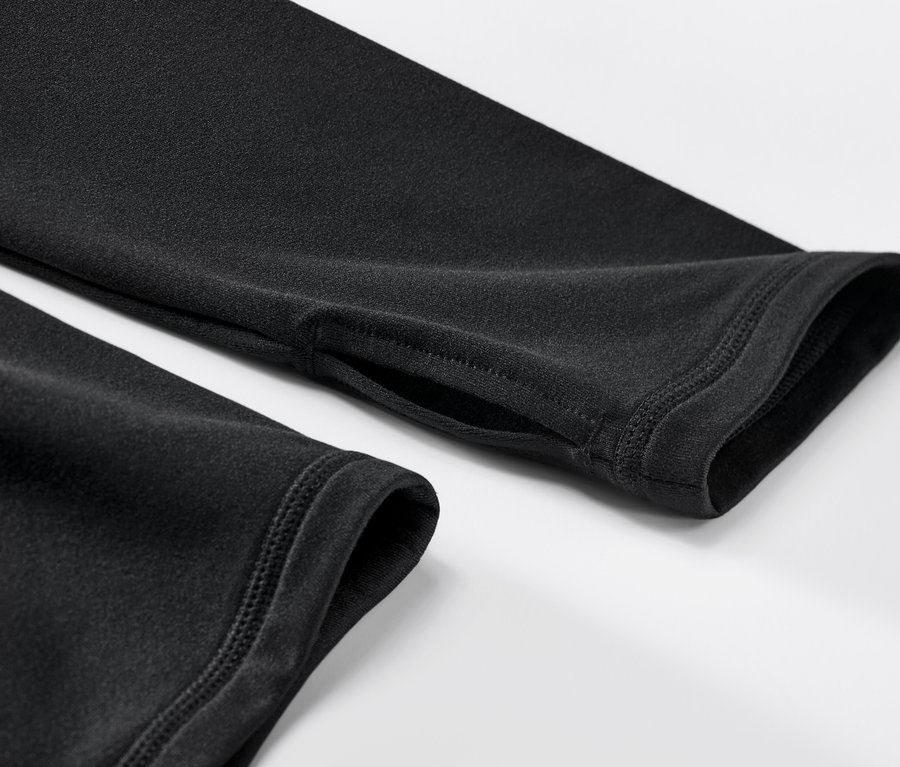 Gros plan sur un t-shirt technique thermique noir avec un trou pour le pouce.