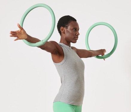 Femme faisant de l'exercice avec 2 cerceaux d'entraînement pour les bras.