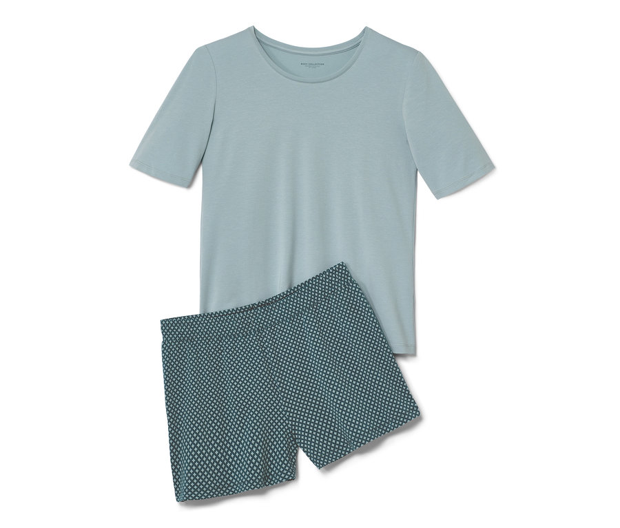 Un pyjashort, composé d'un short avec imprimé intégral et d'un t-shirt à manches courtes bleu clair, est posé sur un fond blanc.