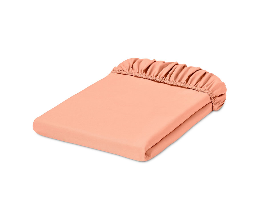 Un drap-housse en percale abricot de taille standard plié.
