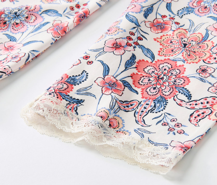 Détail du pantalon de pyjama avec imprimé floral intégral et bordure en dentelle.