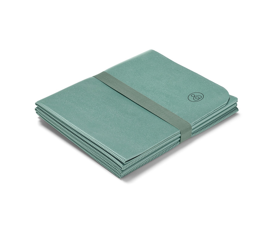 Un tapis de yoga pliable, plié et maintenu par un élastique.