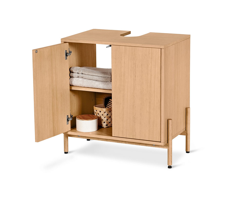 Meuble sous vasque ouvert avec placage en bois, serviettes et panier en osier à l'intérieur.