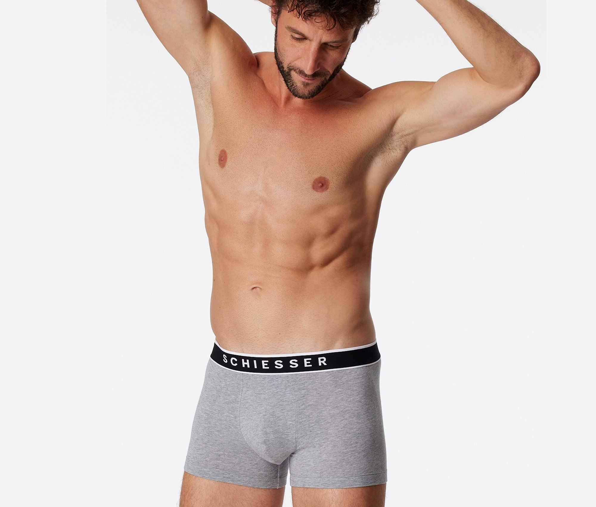 Homme les mains derrière la tête portant 3 boxers SCHIESSER avec coton bio, gris chiné.