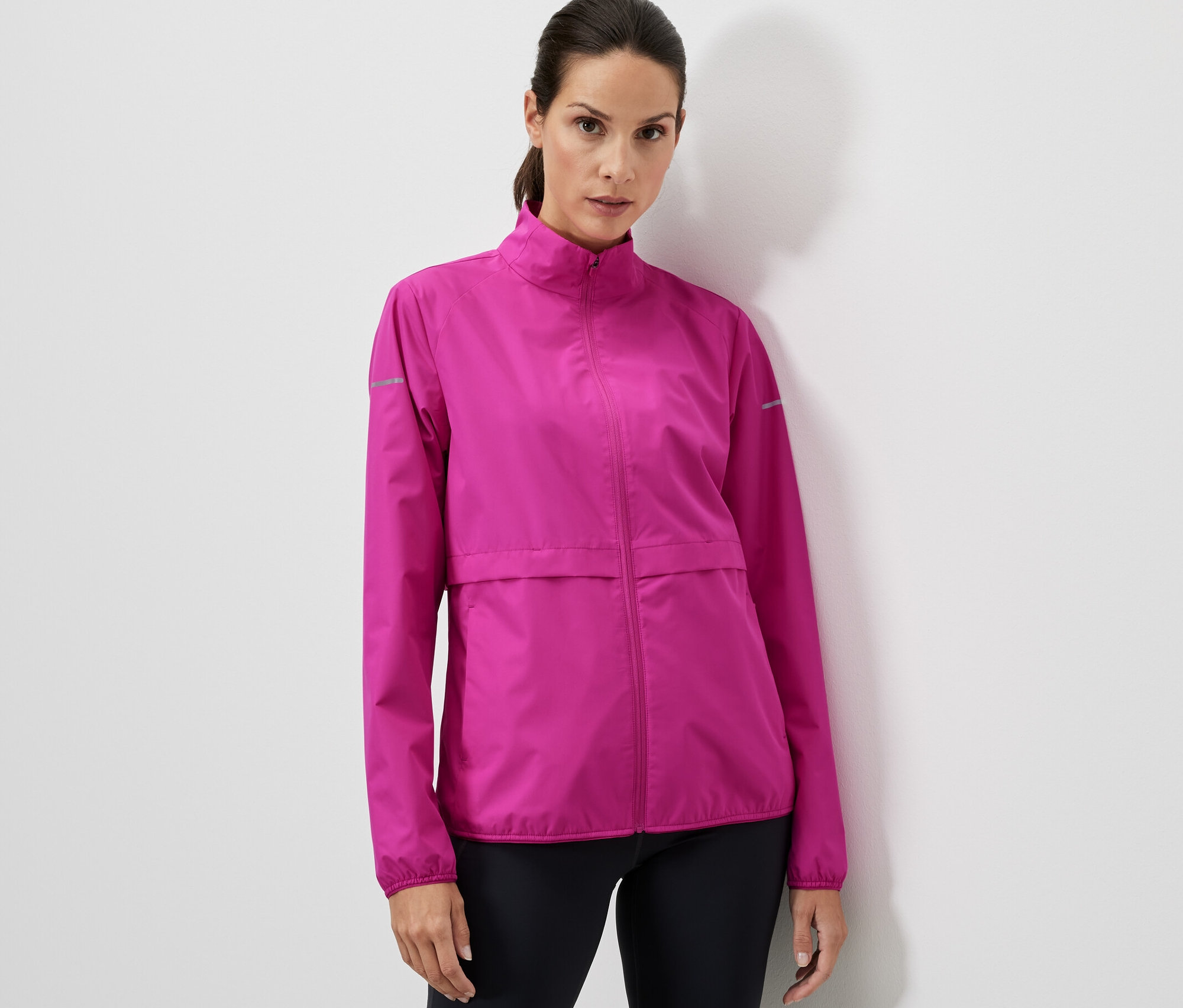 Femme portant une veste de sport coupe-vent rose.