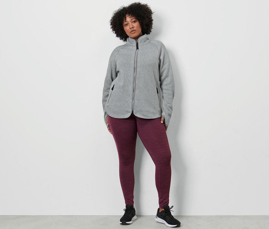Femme portant un legging de sport et une veste en maille polaire gris clair.