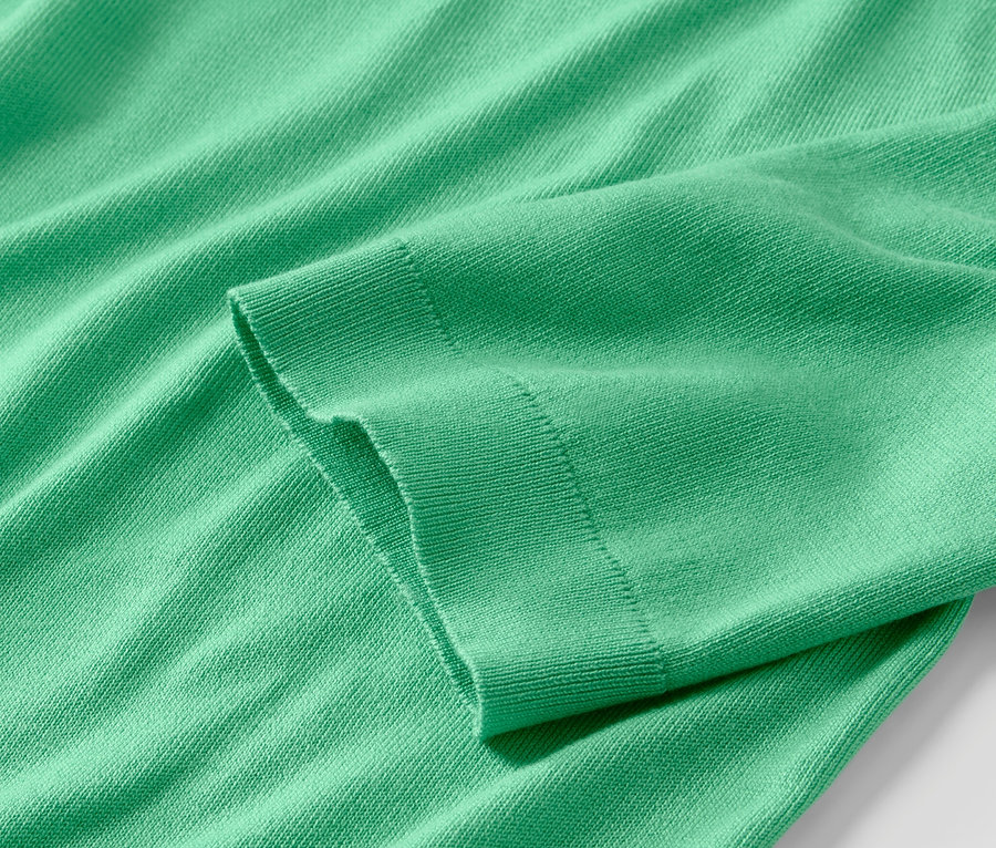 Vue détaillée d'un pull en maille fine vert.