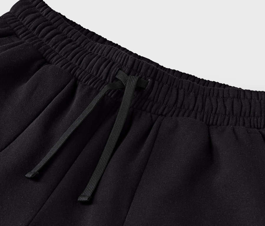 Gros plan sur un pantalon de survêtement noir avec cordon de serrage à la taille.