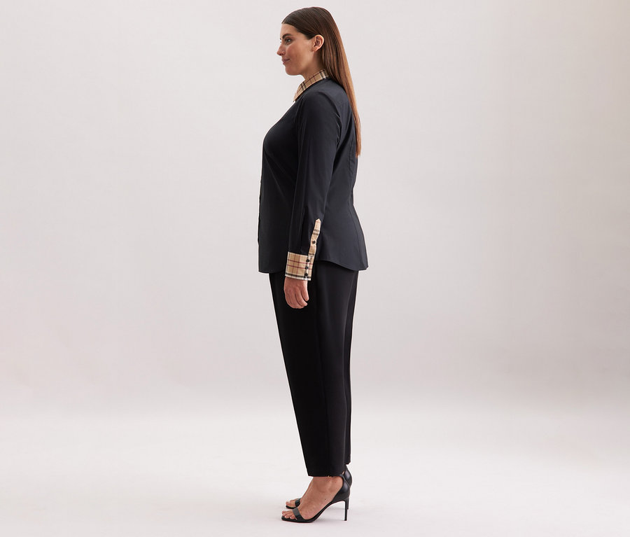 Femme portant un chemisier en popeline à carreaux Seidensticker noir, un pantalon noir et des talons noirs.