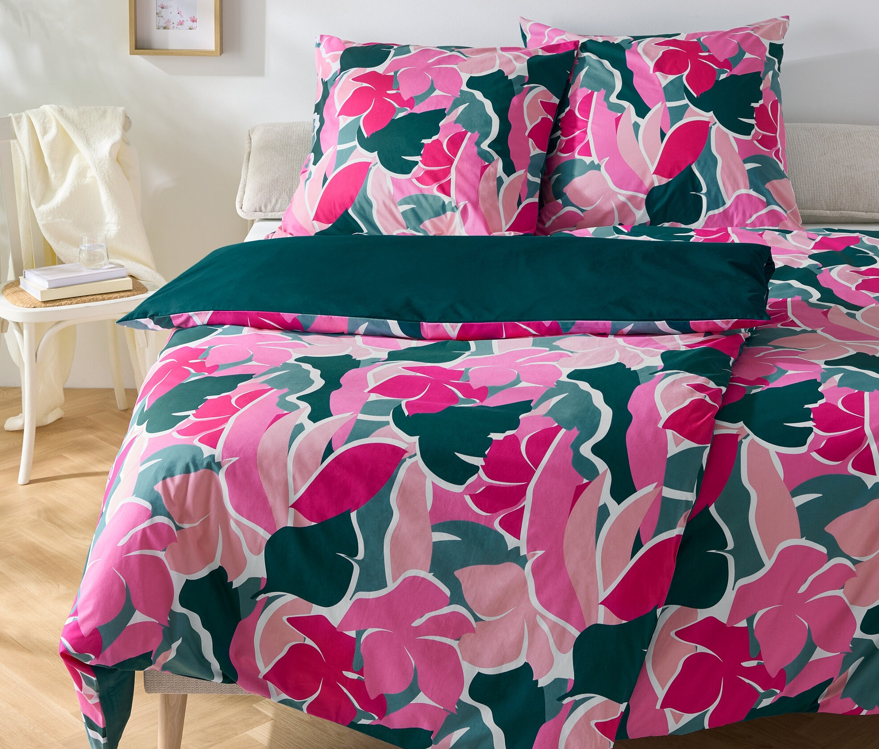 Parure de lit en percale à fleurs, deux tailles normales et une grande taille, disposées sur un lit.