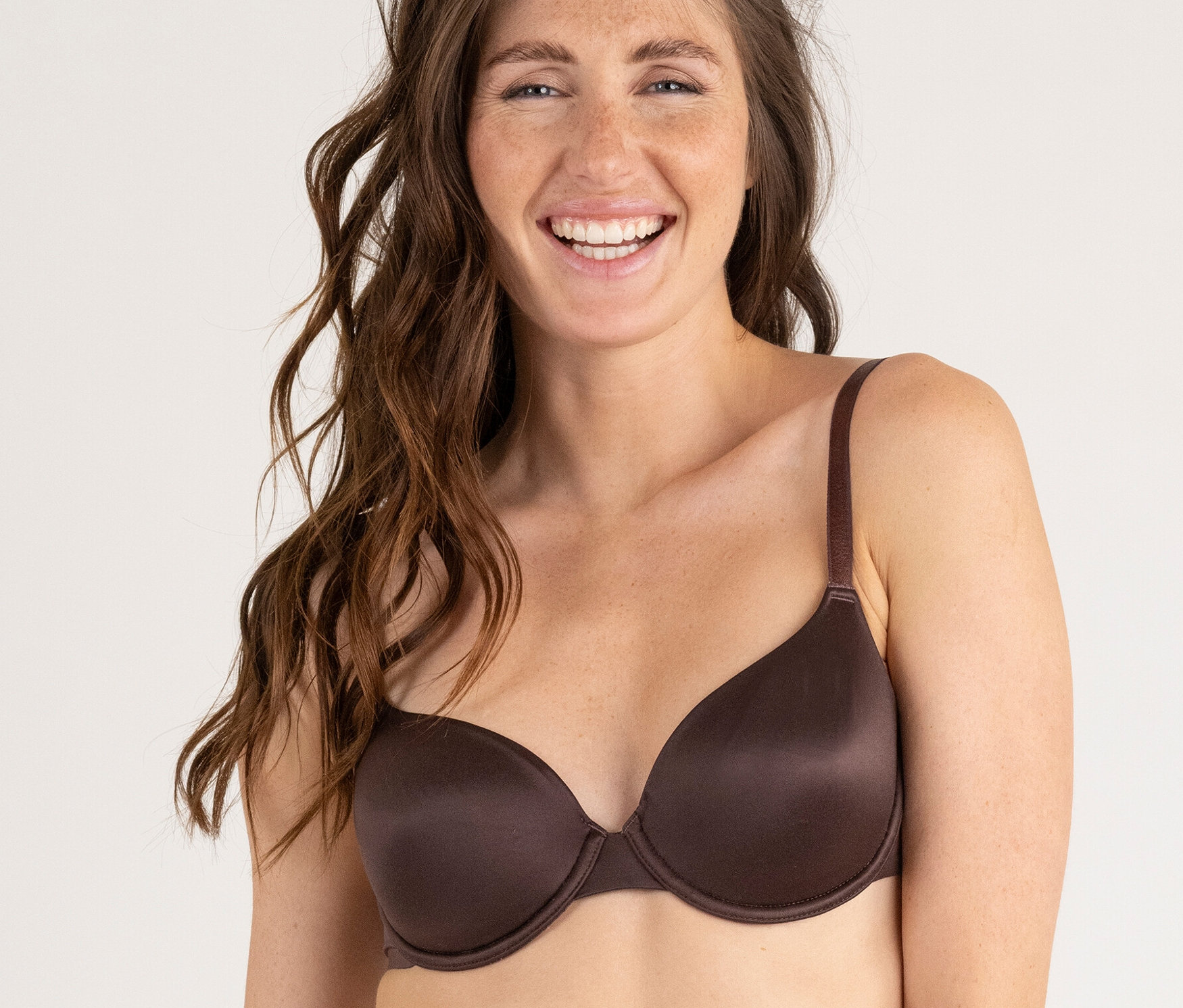 Une femme porte un soutien-gorge et une culotte marron.