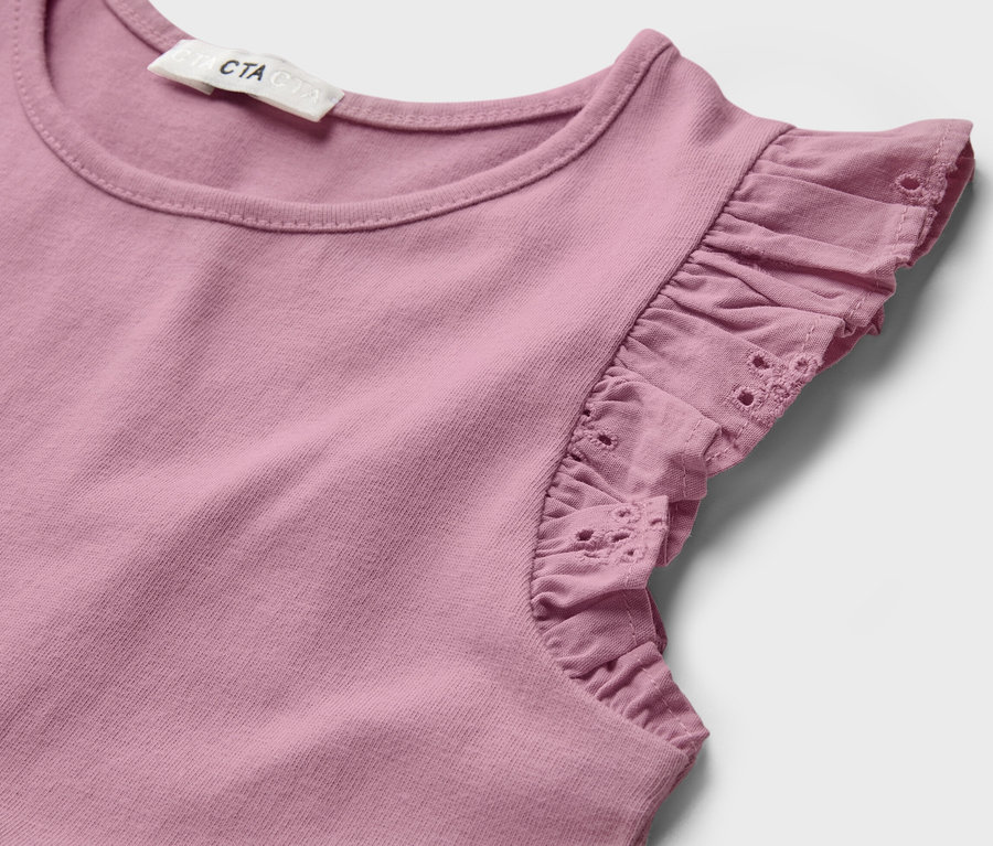 Détail d'une robe pour enfant avec des volants.