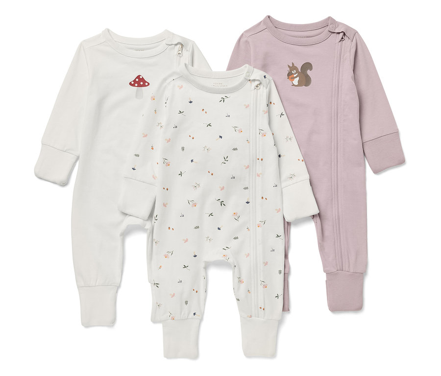 Trois pyjamas bébé à manches longues. Un blanc avec une amanite tue-mouches, un avec un motif floral et un violet avec un écureuil.
