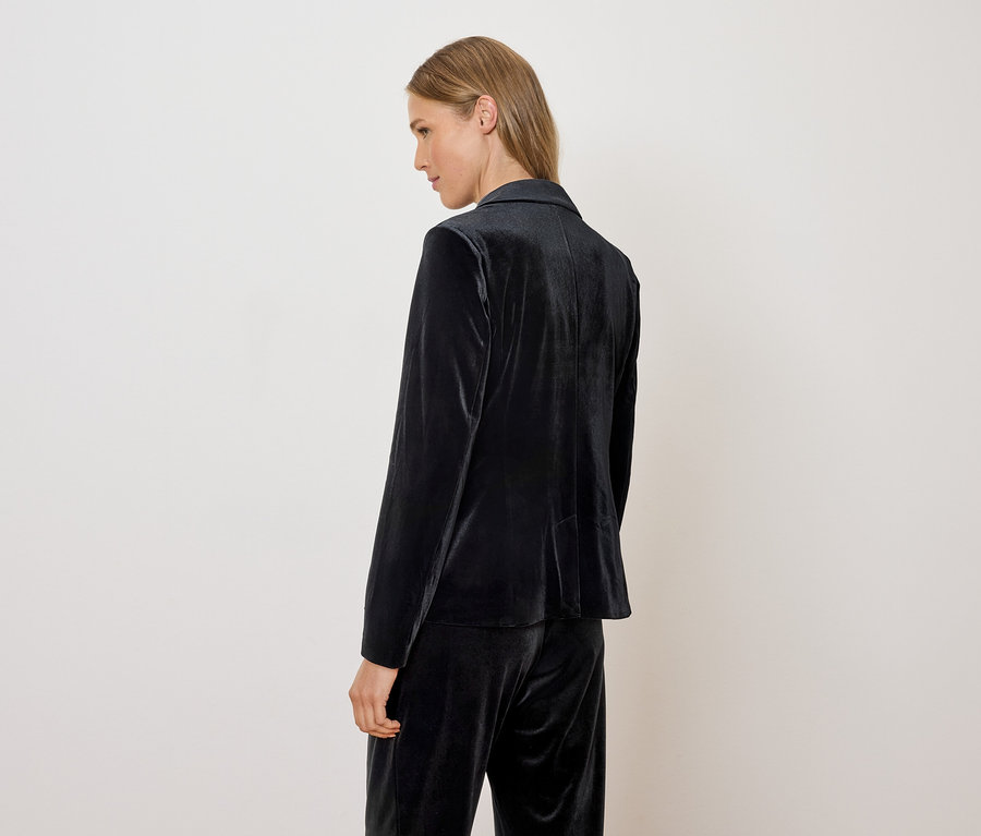Une femme porte un blazer et un pantalon en velours.