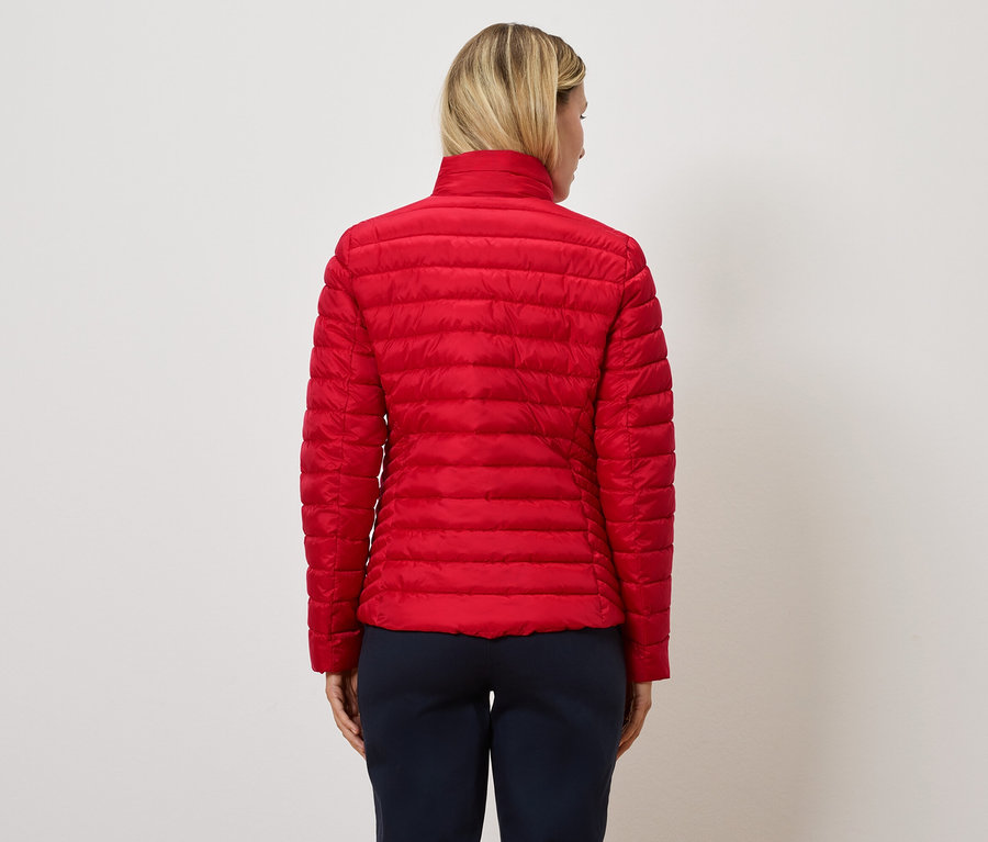 Femme portant une veste matelassée rouge, vue de dos.