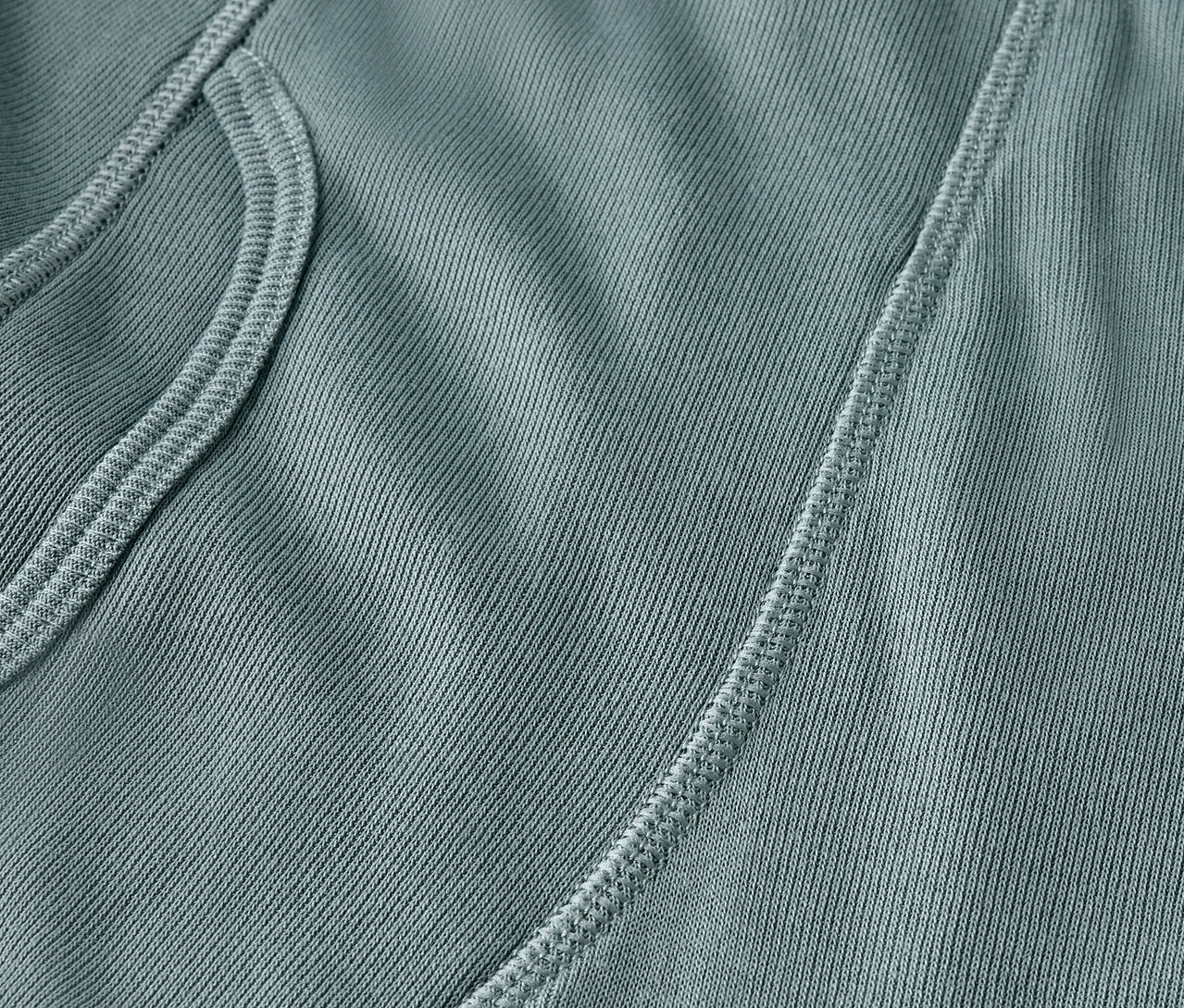 Gros plan d'un tissu bleu-vert avec une poche et une couture.