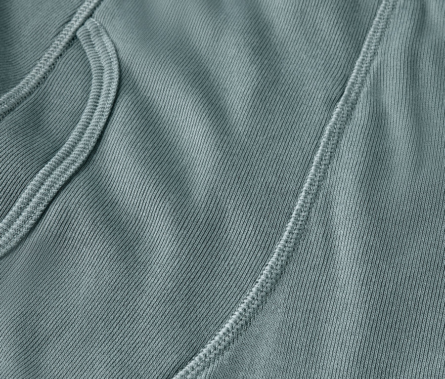 Gros plan d'un tissu bleu-vert avec une poche et une couture.