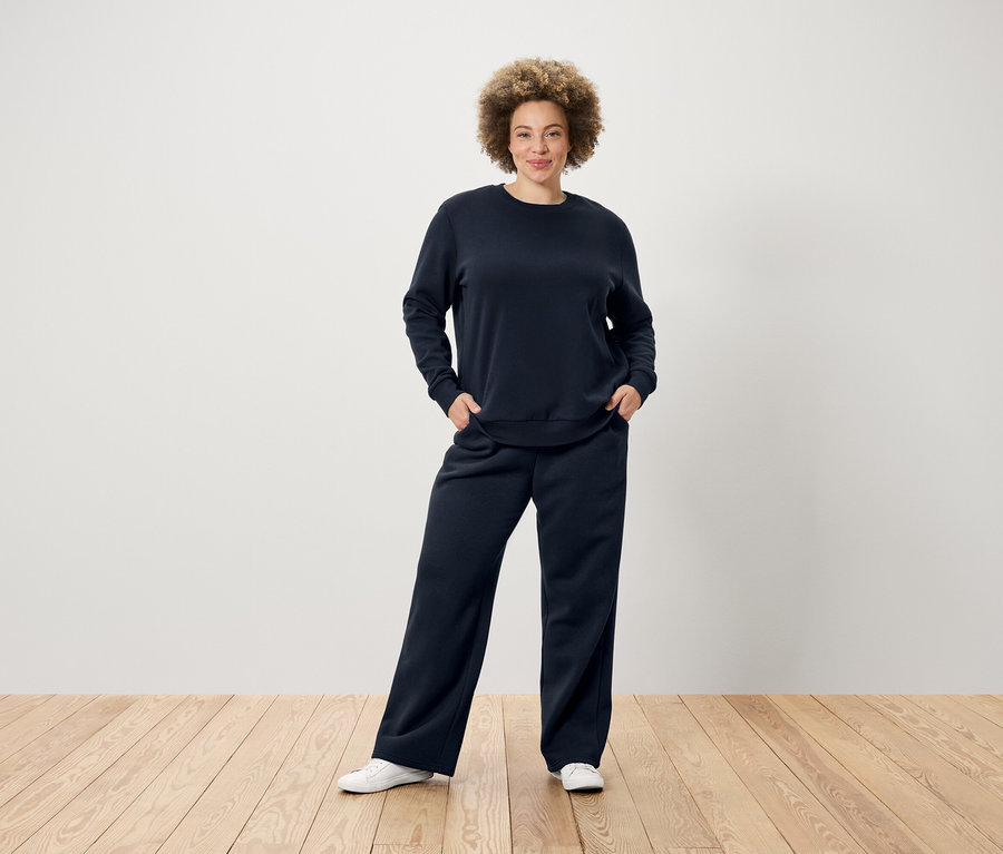 Femme posant en pantalon de jogging bleu foncé.