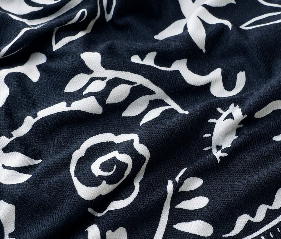 Gros plan d'un tissu bleu marine avec un motif floral blanc.