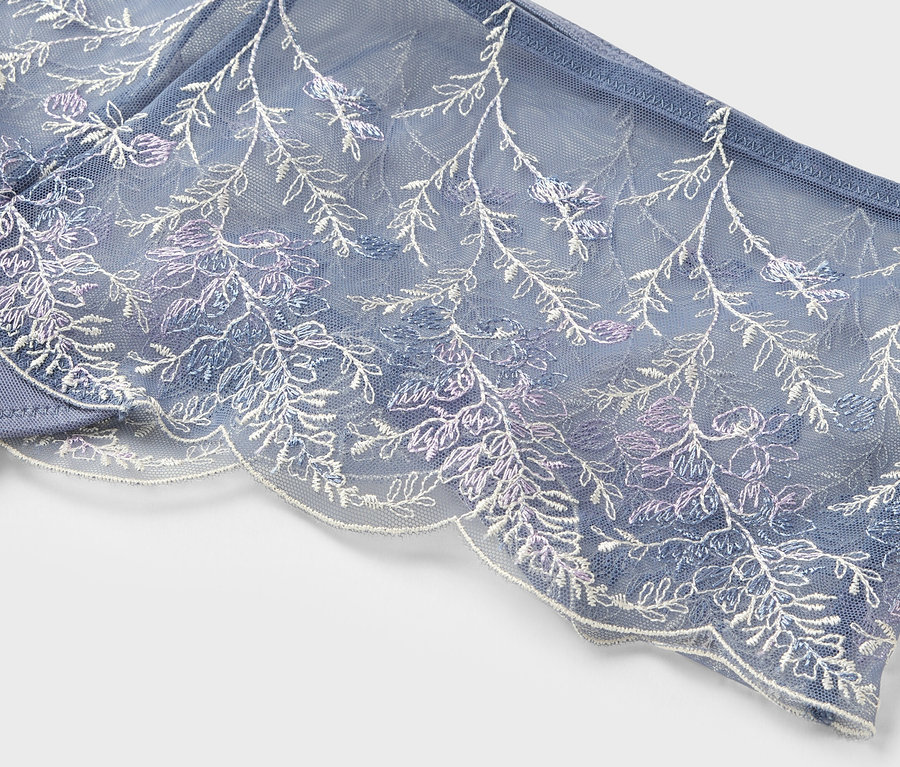 Gros plan d'un soutien-gorge bleu avec de la dentelle florale.