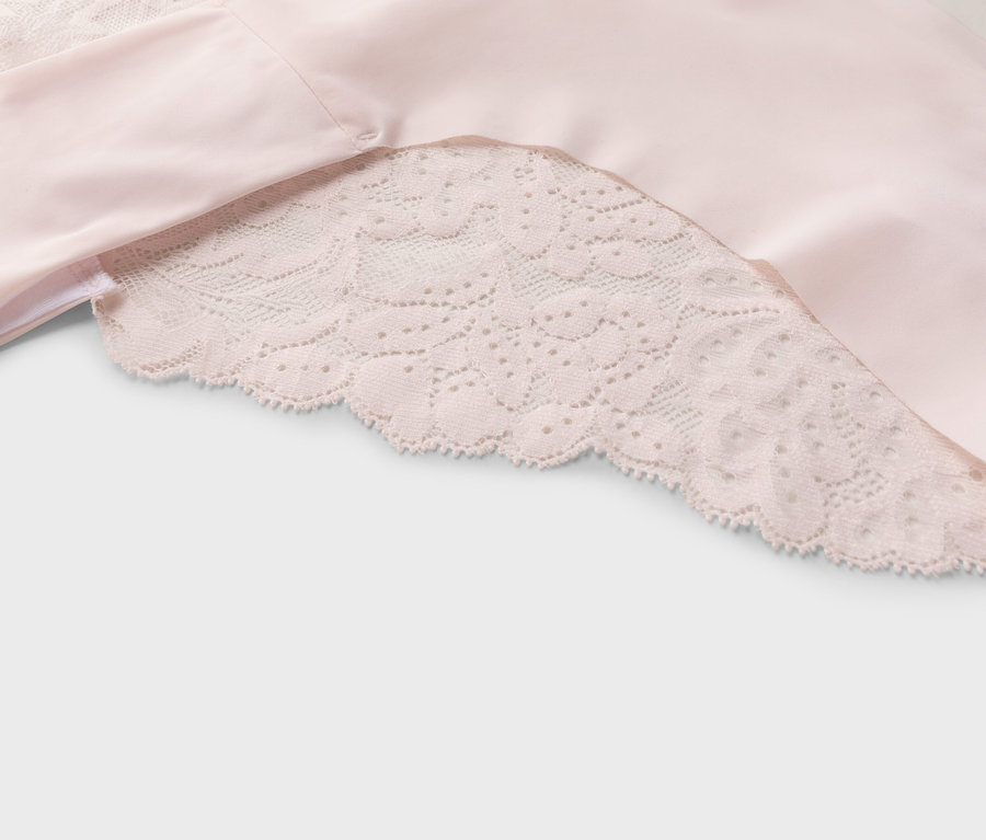 Gros plan d'un tissu rose avec une garniture en dentelle.