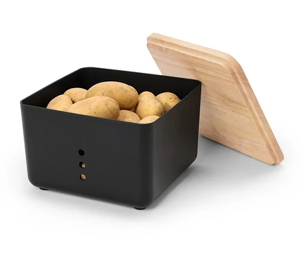 Une boîte à pommes de terre noire remplie de pommes de terre avec un couvercle en bois à côté.