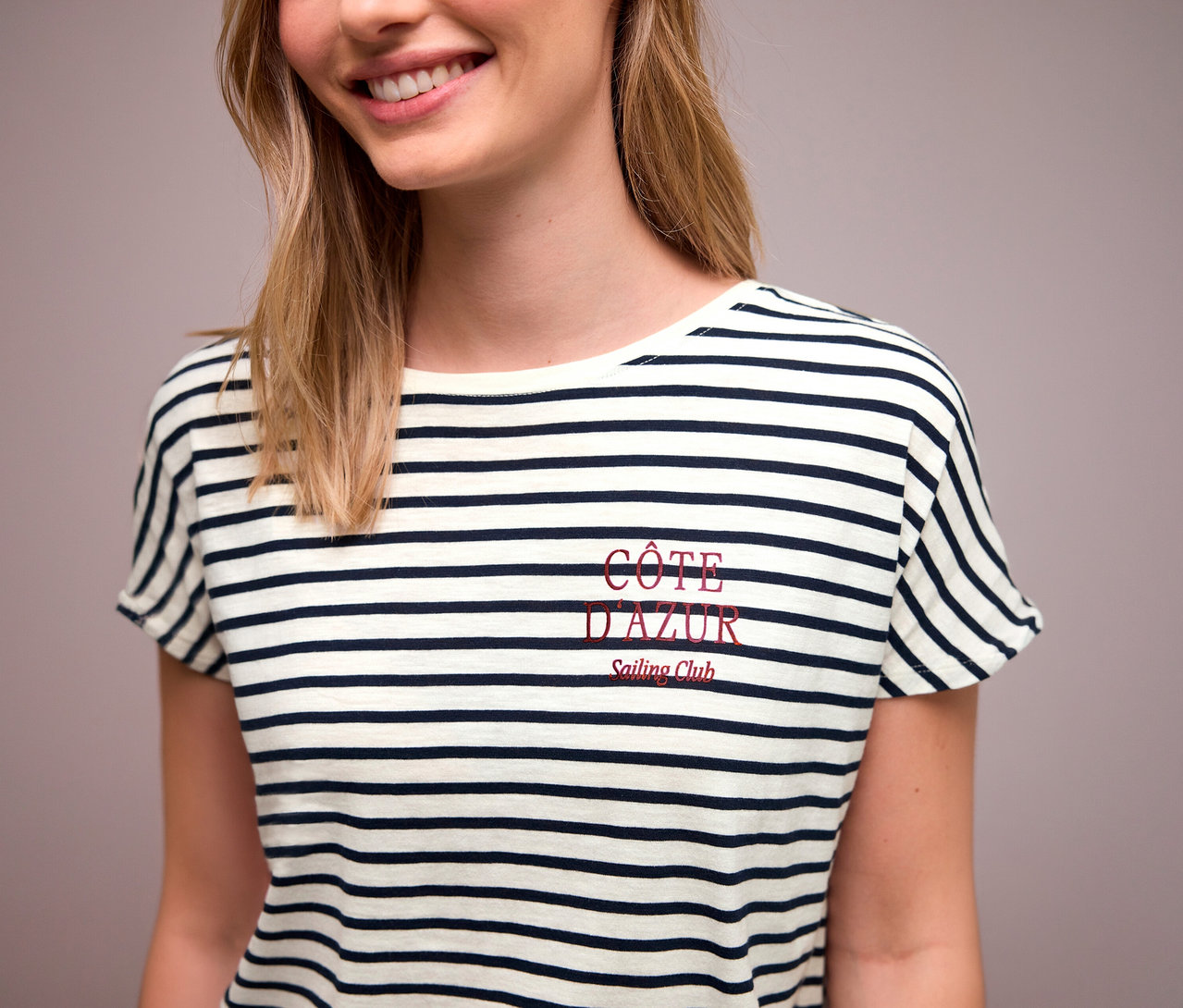 Une femme porte un t-shirt Street One bleu marine et blanc avec l'inscription rouge « Côte d'Azur ».
