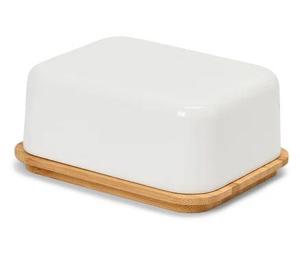 Une beurrier blanche avec un couvercle en bambou sur une surface blanche.
