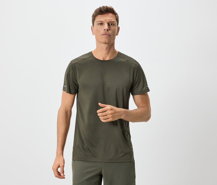 Homme en t-shirt et short vert olive sur fond neutre.