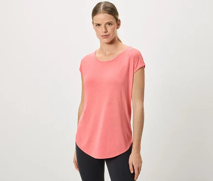 Femme avec queue de cheval portant un t-shirt corail et un legging noir.
