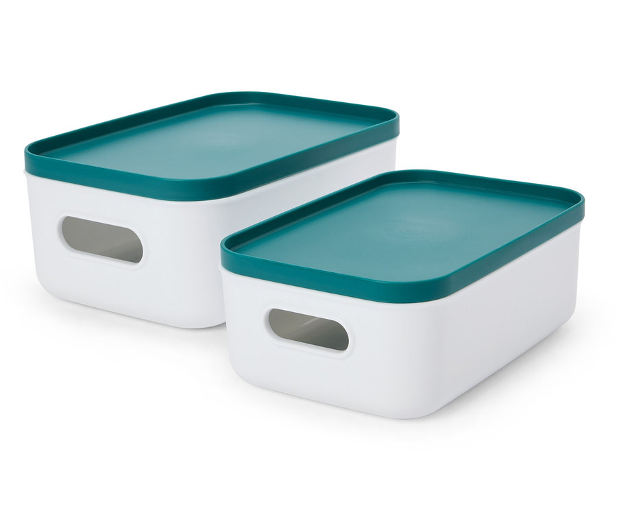 Deux boîtes de rangement blanches avec des couvercles turquoise sont posées sur une surface blanche.