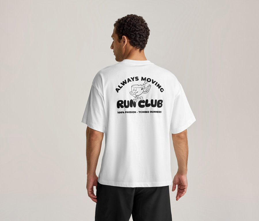 Homme de dos portant un T-shirt de sport blanc avec un imprimé noir "ALWAYS MOVING RUN CLUB" et une tasse de café qui court.