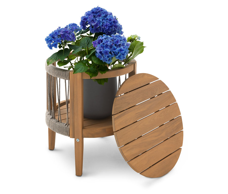 Hortensia bleu en pot gris sur une table d'appoint en bois à deux niveaux avec un plateau de table ovale posé à côté.