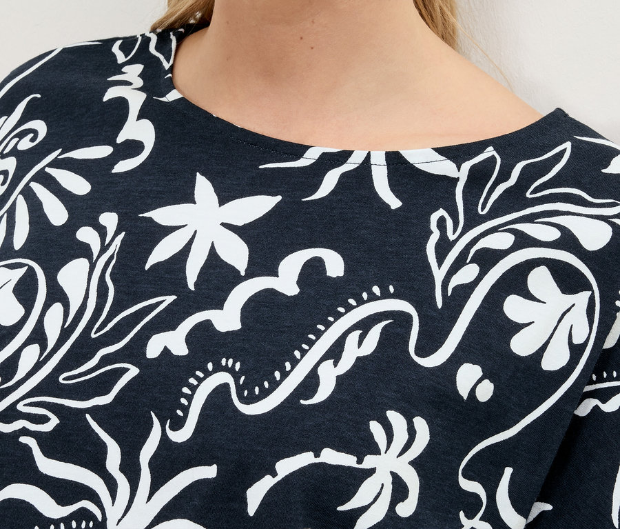 Gros plan sur un haut bleu marine avec un motif floral blanc.