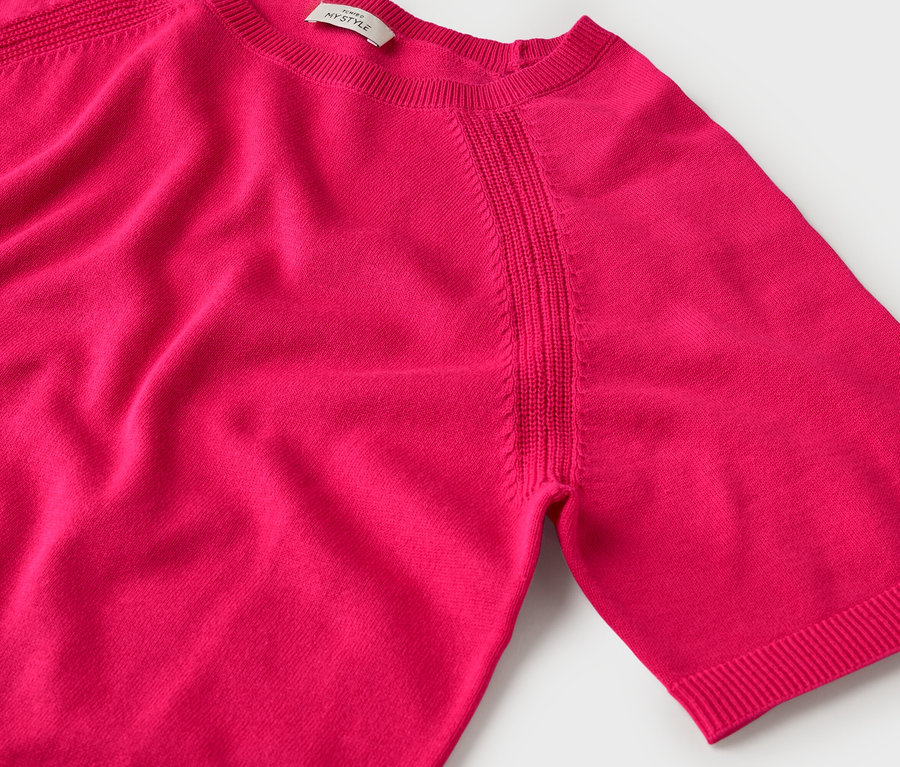 Gros plan sur un pull en tricot rose à manches courtes.