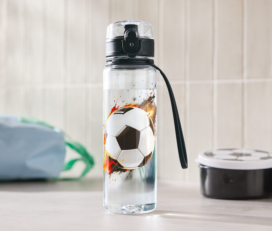 Une bouteille d'eau avec un motif de ballon de football est posée sur une table.