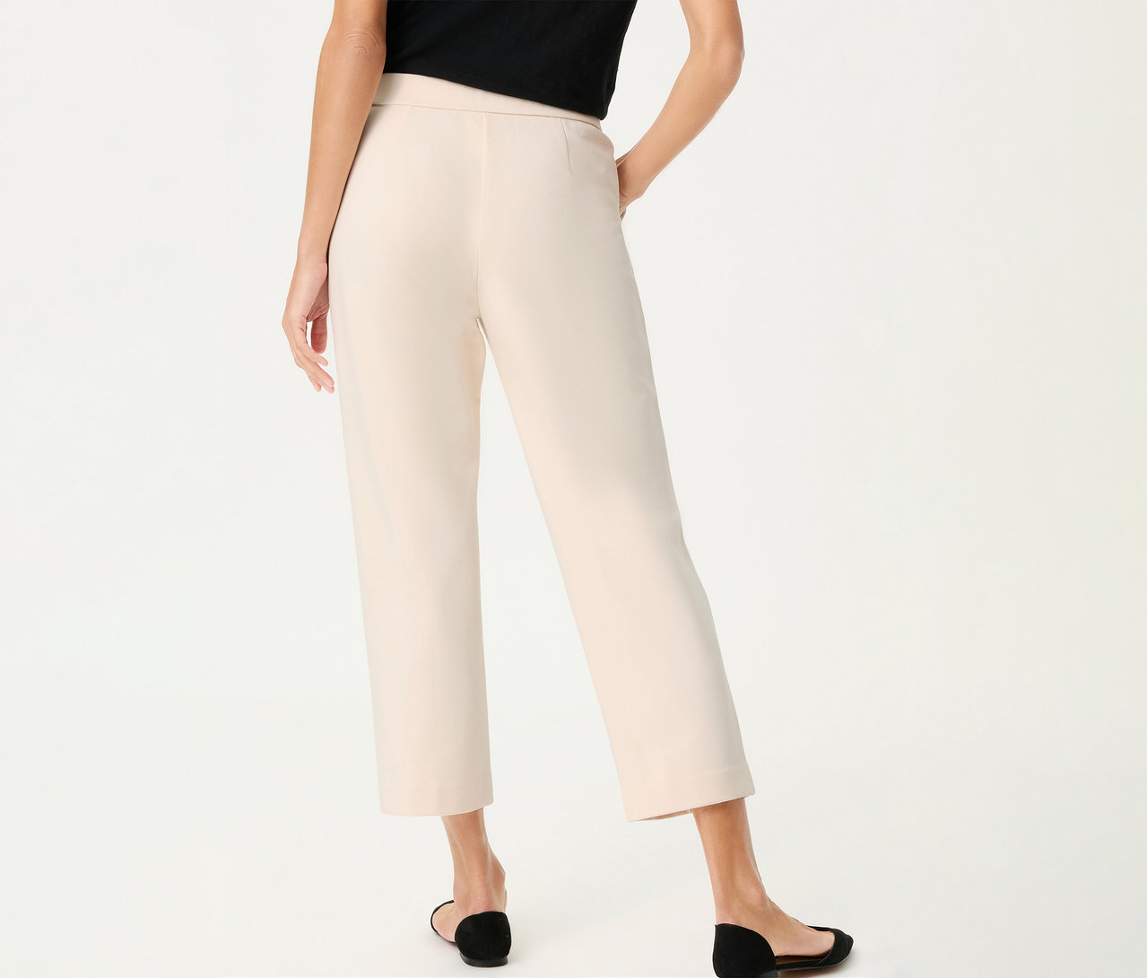 Vue arrière d'une femme portant un pantalon en lin Olsen, cropped, et des chaussures noires sur fond blanc.