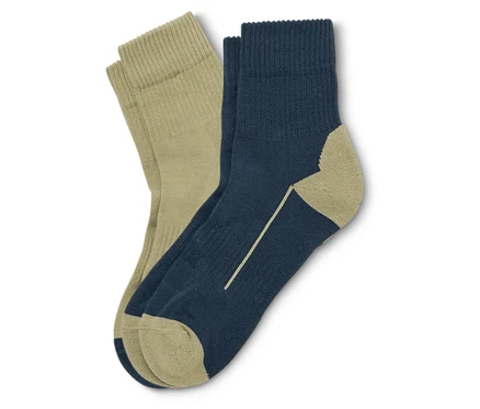 Une paire de chaussettes, une beige et une bleu marine avec des détails beiges, sont posées l'une sur l'autre.