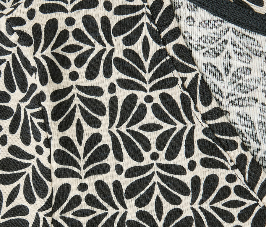 Gros plan sur un t-shirt Street One avec motif noir à feuilles et pois et encolure en V.