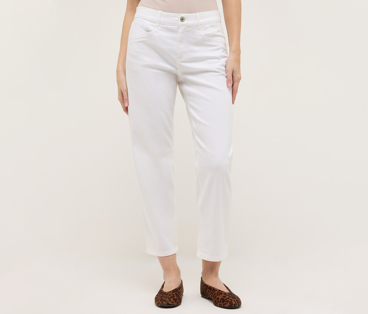Une femme porte un jean blanc Angels Denim « Evy Cool » O-Shape et des ballerines marron à imprimé animal sur fond clair.