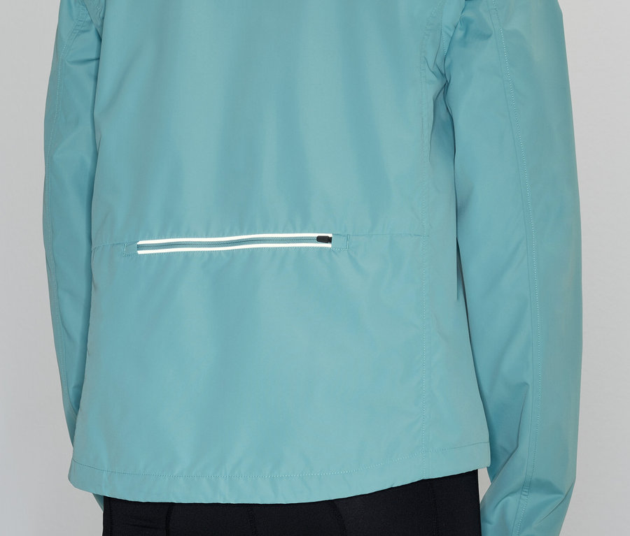 Vue arrière d'une personne portant une veste bleu clair avec une poche horizontale réfléchissante.