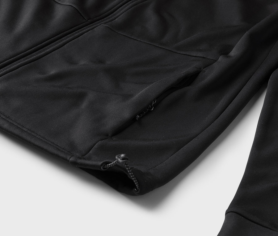 Gros plan sur un survêtement noir zippé avec une poche zippée sur la manche.