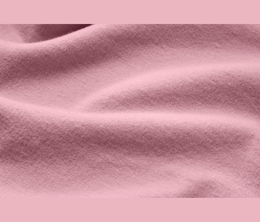 Gros plan sur un tissu rose doux avec des plis délicats et une texture visible.